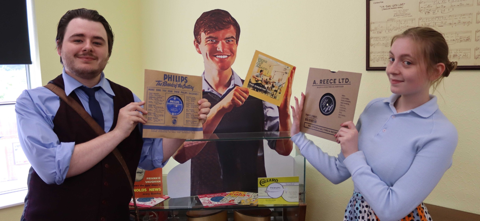 People holding records at the 1950s record shop at Beamish Museum