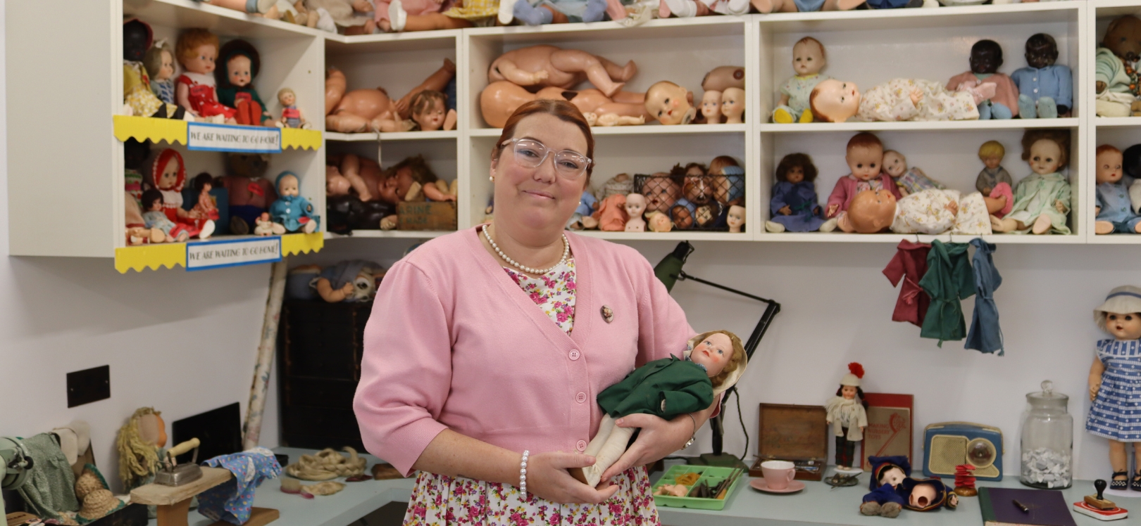 The 1950s toy shop including a dolls hospital, a woman is holding and toy doll.