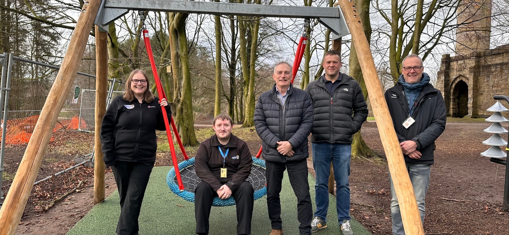 A group of people sat on the swings at Hardwick Park