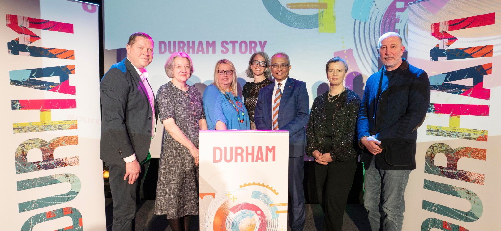 People stood in front of the Durham Story board and banners